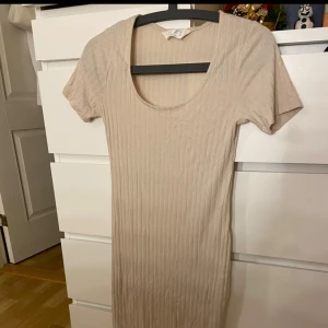 Beige lång klänning - Beige & lång klänning. Den är i ett tunt material, går till under knäna & har aldrig använts🤍Fler bilder kan skickas privat vid förfrågan! 