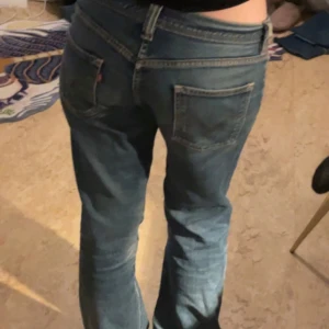 Blå jeans från Levi's - Säljer ett par klassiska blå jeans från Levi's. De har en låg midja och en straight/flared passform.   Midjemått: 38cm     Innerbenslängd: 77cm