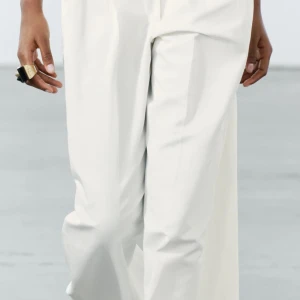 Cremevita kostymbyxor M nya!  - Snygga cremevita kostymbyxor med hög midja och vida ben. Byxorna har knappar i midjan och en stilren design som passar perfekt för en elegant look. Ser verkligen lyxiga ut! Säljes pga fel storlek. Nypris 559kr