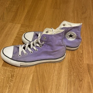 Lila Converse All Star sneakers - Säljer ett par lila Converse All Star sneakers i klassisk hög modell med vita snören och sula💜
