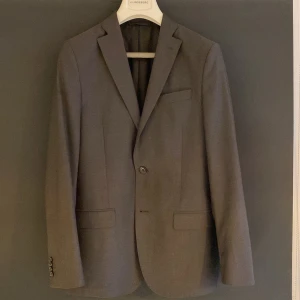 Svart kavaj från J. Lindeberg - Snygg svart kavaj från J. Lindeberg i slim fit. Kavajen är i storlek 46 och passar mig perfekt som är 175. Använd fåtal gånger och inga tecken på användning. Nypris runt 3000kr.