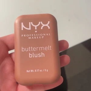 Buttermelt Blush från NYX - Säljer en NYX Professional Makeup Buttermelt Blush i nyansen 'Feeling Butta'. Denna rouge har en smörig textur och kommer i en kompakt förpackning på 5 g. Perfekt för att ge kinderna en naturlig och fräsch färg.
