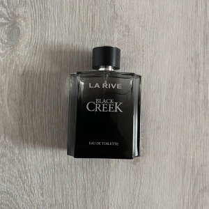 La Rive Black Creek Eau de Toilette 100ml - Elegant och maskulin doft från La Rive. Black Creek kommer i en stilren svart flaska med silverdetaljer. 100 ml aldrig använd ! 