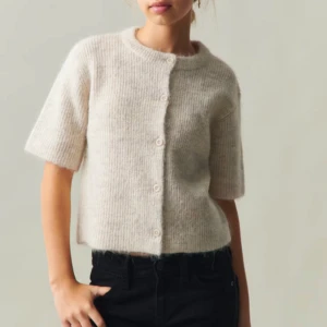 Beige stickad kofta - Stickad kofta med korta ärmar. Använd 1 gång så i princip nyskick och slutsåld. 