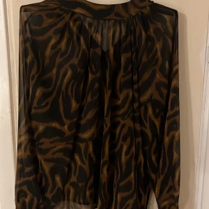 En blus från H&M. Den ger leopard effekt. Älskar men har it haft på mig den så mycket o ser mig it ha den heller. - Den är i storlek S älskar den men e ganska vågad tröja för min smak.