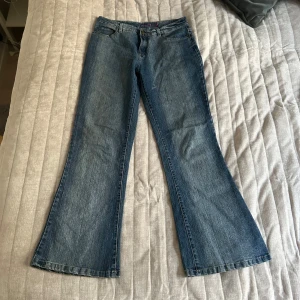 Blå bootcut jeans - Snygga blå bootcut jeans med klassisk femficksdesign. Perfekta för en avslappnad stil med en touch av retro. Passar bra till både sneakers och klackar.