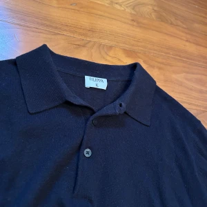 Pikétröja från Filippa K - Skön mörkblå pikétröja från Filippa K med klassisk krage och knappar framtill. Passar utmärkt tillsammans med en skjorta under men samtidigt en vanlig T-shirt. Går jättebra att använda till en dag på plugget, till en utekväll men även en lugn dag hemma! Hör av dig för fler funderingar!