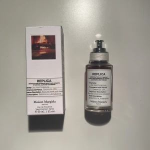 Parfym 'By the Fireplace' från Maison Margiela - Upptäck 'By the Fireplace' från Maison Margiela, en Eau de Toilette som fångar doften av en mysig vinterkväll vid eldstaden. Med noter av kastanj, trä och sötma ger den en varm och inbjudande känsla. Flaskan är elegant med en stilren etikett och en praktisk sprayfunktion. Perfekt för att skapa en nostalgisk atmosfär.