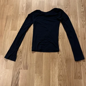 Marinblått långärmad topp från Ginatricot i storlek xxs - Säljer en stilren marinblått långärmad topp. Perfekt för en minimalistisk look. Toppen har en enkel design med långa ärmar och är tillverkad i ett mjukt material.