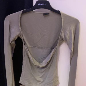 Grå långärmad topp från Gina Tricot - Säljer en stilren grå långärmad topp från Gina Tricot. Toppen har en tight passform och tyvärr kommer inte den till någon användning längre. 