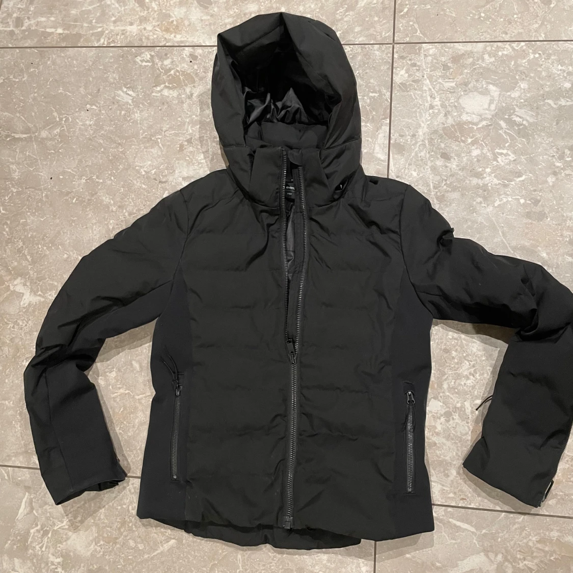 Svart skidjacka med huva