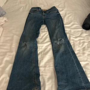 Blå jeans från Vero Moda - Säljer ett par blå jeans från Vero Moda med slitna detaljer på knäna. Är 1,60 och passar super fint! 
