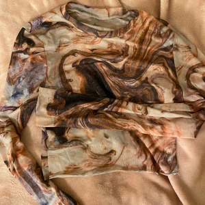 Genomskinnlig festtopp - En färgglad genomskinnlig festtopp🩶Aldrig använd. Den är långärmad & är i ett ostretchigt material. Den är i en storlek M, däremot anser jag att den är en vanlig S. Säljer också en likadan fast kortärmad☝🏼