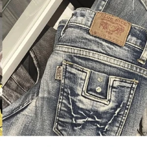 Snygga blåa lågmidjade jeans - Säljer dessa super nygga blå jeans från Blue Nice med slitna detaljer och låg midja. De har en bootcut-stil och klassiska design. Bra kvalitet och både ser och är nästan nya!💕