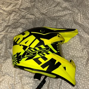 Gul och svart hjälm från Raven - Säljer en gul och svart hjälm från Raven med Hjälmen har en skärm och integrerade glasögon med gul toning. Perfekt för motocross eller liknande aktiviteter. Både glasögonen och hjälmen är nästan helt nya
