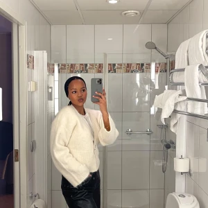 Vit stickad kofta med knapp - Säljer en mysig vit stickad kofta med en knapp framtill. Perfekt för kyliga dagar och lätt att matcha med olika outfits. Koftan har en enkel och stilren design.