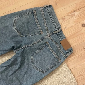 Ljusblå weekday-jeans - Snygga blå jeansbyxor med klassisk femficksdesign och mid-waist. Perfekta för en avslappnad stil. De har en rak (straight) passform och är tillverkade i slitstarkt denim. De är ljusare i verkligheten, bilderna får de o se ut som en mörkare blå. Nypris: ca 500 kr. Om eventuella frågor, skriv💕