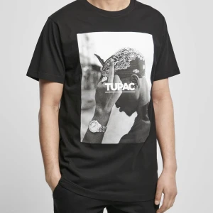 Svart T-shirt med 2pac-tryck - Snygg svart T-shirt med ett stort tryck av Tupac på framsidan. T-shirten är knappt använd eftersom att den inte faller mig i smaken. TOPP skick. Tveka inte på att höra av er vid frågor eller fler bilder!!!