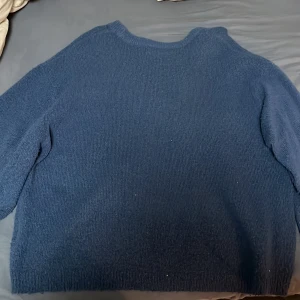 Mörkblå stickad tröja från 157 - Säljer en mysig mörkblå stickad tröja från 157. Tröjan har en rund halsringning och långa ärmar, perfekt för kyliga dagar. Den är enkel och stilren, vilket gör den lätt att matcha med olika outfits.