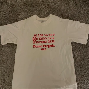 Maison Margiela T-shirt  - Maison margiela tshirt i vitt med det ikoniska röda trycket. Oversized som passar både S och M.