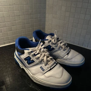 New Balance 550 sneakers i vitt och blått - Snygga New Balance 550 sneakers i vitt med blå detaljer. Knappt använda. Köpta för 1600.