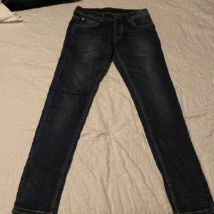 Mörkblå jeans från River Soul - Snygga mörkblå jeans från River Soul med klassisk femficksdesign. De har en rak passform och är perfekta för en avslappnad stil. Jeansen har en knappgylf och är tillverkade i slitstarkt denim.