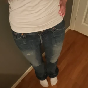 Lågmidjade Levis jeans - Lågmidjade levis jeans med slitningar. Säljer då de inte kommer till användning.