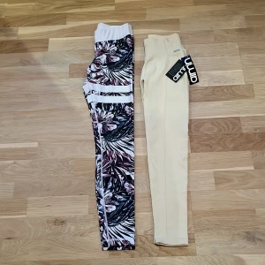 Träningsbyxor - Två par snygga trännngsbyxor. Ett par mönstrade leggings från Stronger i blommigt mönster och ett par beige byxor från Aim'n😍😍Mycket bra skick på båda. Aim’n byxorna är helt nya och lappar kvar. Stronger byxorna använda fåtal gånger. Alltså nyskick på båda. 🥰🥰