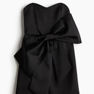 Satin klänning med rosett - Säljer denna populära slutsålda klänningen från hm, aldrig använd och endast provad säljer då jag köpte fel storlek. Priset går att diskutera vid snabb affär!