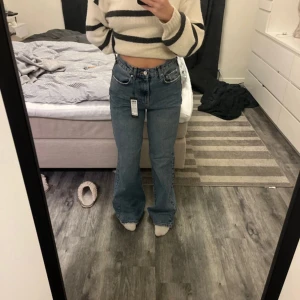 Blå jeans från Vero Moda - Säljer ett par blå jeans från Vero Moda i modellen Super High Rise Regular Wide. De har en klassisk femficksdesign och är tillverkade i denim. Perfekta för en avslappnad stil.