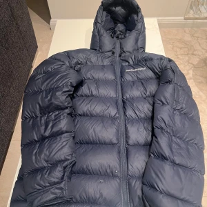 Peak Performance Herr Vinterjacka Storlek S - Peak Performance Herr Vinterjacka i Storlek S, men kan även passa M. Den är i fint skick, förutom att den har två små hål som har limmats, där av priset.