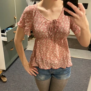 Söt blus med blommor - Söt blommig top! Säljer då jag inte använder den så ofta. Står inget märke eller storlek men gissar på M!