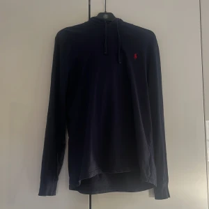 Mörkblå hoodie från Polo Ralph Lauren - Sjukt snygg Mörkblå hoodie från Polo Ralph Lauren med en liten röd logga på bröstet. Storlek M