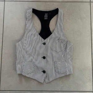 Gråvit-randig väst, Filippa K - En väldigt snygg, helt oanvänd grå- och vitrandig väst från Filippa K. 