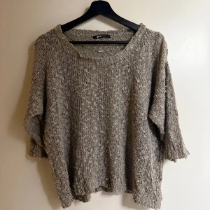 Beige stickad tröja från Gina Tricot - Mysig beige stickad tröja från Gina Tricot med en loose passform. Perfekt för kyliga dagar med sin texturerade yta och trekvartsärmar. Enkelt att matcha med olika outfits.