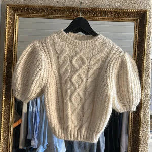 Vit stickad tröja från Zara - Säljer en superfin vit stickad tröja från Zara med puffiga ärmar och ett snyggt flätmönster framtill. OANVÄND 