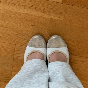 Vita ballerinaskor med glittrig tå - Snygga vita ballerinaskor med glittriga detaljer på tå och häl. Perfekta för en stilren look med en touch av glamour. Använda men i bra skick!