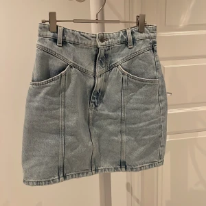 Jeanskjol - Blå jeanskjol med både fram och bak fickor. 