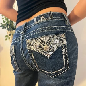 Miss Me Jeans  - (18) Så snygga Miss me jeans!💓 De är bootcut men för långa på modellen som e 164cm. Observera att hon håller jeansen där bak då de är för stora!  Waist: 30 Modell: Signature slim boot Midjemått tvärs över: 42cm Innerbenslängd: 81cm  Bootcutbredd:22cm