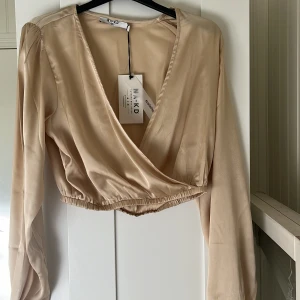 Champagnefärgad blus - En oanvänd champagnefärgad blus från NA-KD, katt finns i hemmet!