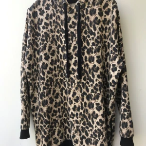 Leopard mönstrad luvtröja  - Snygg mjuk och ganska lång luvtröja med dragkedjor i båda sidorna. Ren och hel.