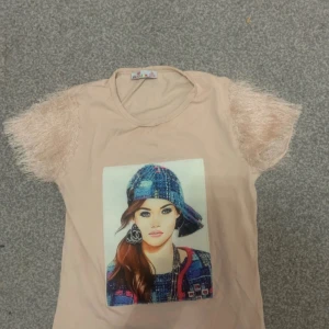 Vacker rosa tröja med bild - Jag säljer en rosa tröja med en fin bild på och material på armen. Den är super vacker och cool för barn. Den är för barn som är 10 år eller yngre