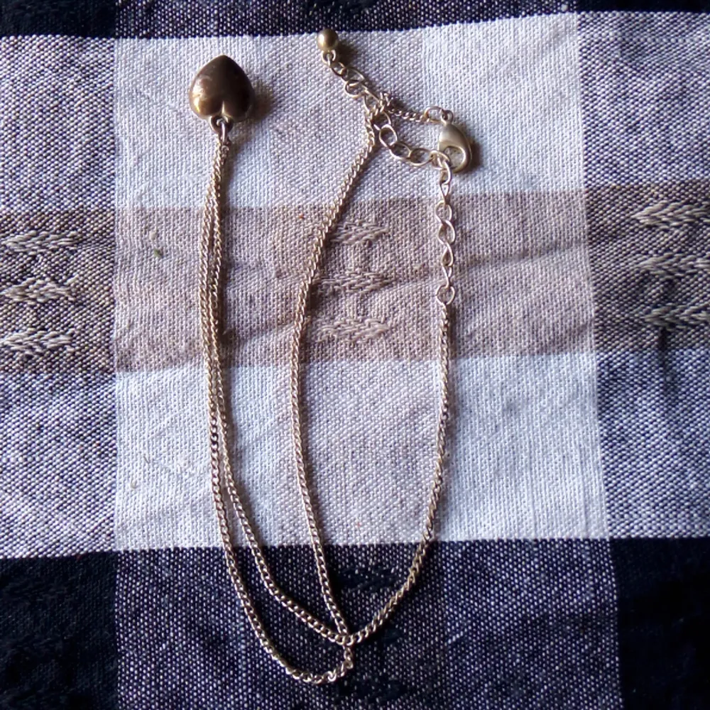 Säljer ett fint silverfärgat halsband med ett hjärthänge. Kedjan är tunn och elegant, perfekt för både vardag och fest. Hänget har en vintage-look med en lite sliten yta som ger det karaktär. Längden på halsbandet är justerbar med en liten kedja och lås.. Accessoarer.