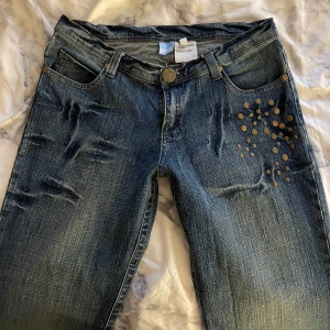 Lågmidjade Bootcut Jeans  - Säljer dessa lågmidjade jeans med guld detaljer. Vet ej storlek men måtten finns på bilden💗 Skriv för bilder och frågor. Pris kan diskuteras 