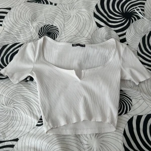 Vit T-shirt  - Vit T-shirt med en liten öppning vid brösten, använd 1 gång 