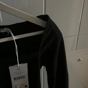 Söt topp från nakd✨ - Säljer min fina topp från nakd, aldrig använt pågrund av att den inte passade mig. Storlek XS💕✨ Svart, ny med prislapp. Som man ser på bilden så går den ner vid bröstet! 