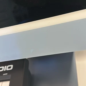 iMac 24 - Bilderna visar en modern datorarbetsstation med en tunn skärm, tangentbord och mus. Skärmen har en elegant design med en smal ram och står på ett stilrent stativ. 