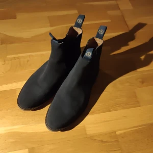 Svarta Chelsea boots från Henri Lloyd - Snygga svarta Chelsea boots från Henri Lloyd.. Perfekta för en stilren look med elastiska paneler på sidorna.