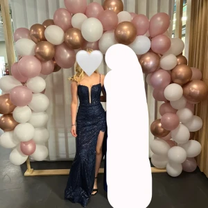 Glittrig balklänning med slits - Säljer nu min balklänning då jag endast har använt den en gång och den inte kommer komma till användning igen.                                                                      Det är en marinblå mermaid-klänning med paljetter och snörning i ryggen.   Passar mig som vanligtvis är en XS/S.   Den är även kemtvättad.    Nypris: 1699 kr   Mitt pris: 1350 kr + frakt, kan gå ner i pris vid snabb affär. Vill du ser fler bilder är det bara att skriva. 