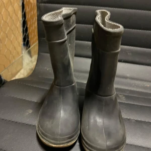 Svarta barn gummistövlar - Praktiska svarta gummistövlar med robust sula. Perfekta för regniga dagar och leriga underlag. Enkla att ta på och av.